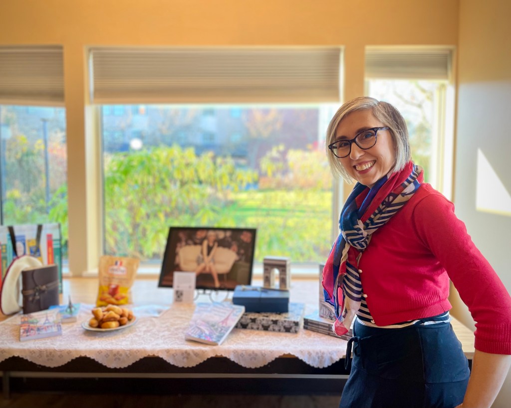Sonia Nicholson posing in front of display table at author event. 