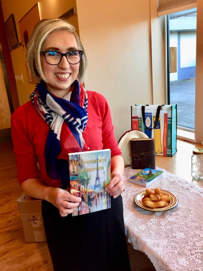 Author Sonia Nicholson holding copy of her book, Provenance Unknown.