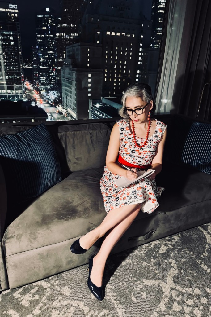 Author Sonia Nicholson. Colour, 1950s style photo taken against backdrop of city at night.