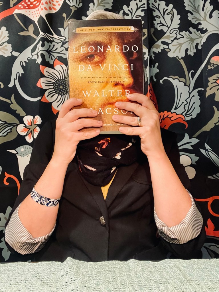 Author Sonia Nicholson doing a “book face” photo with the Leonardo da Vinci book described above.