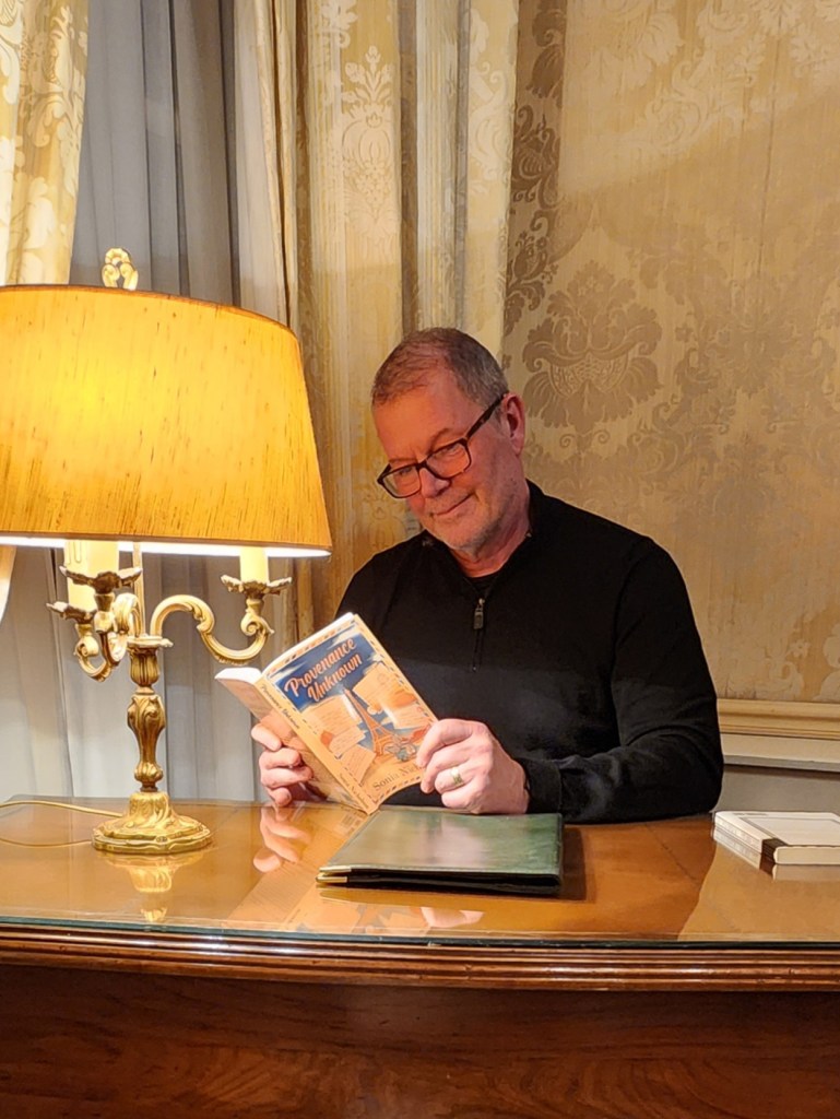 Author John Vintar holding book Provenance Unknown by Sonia Nicholson. 